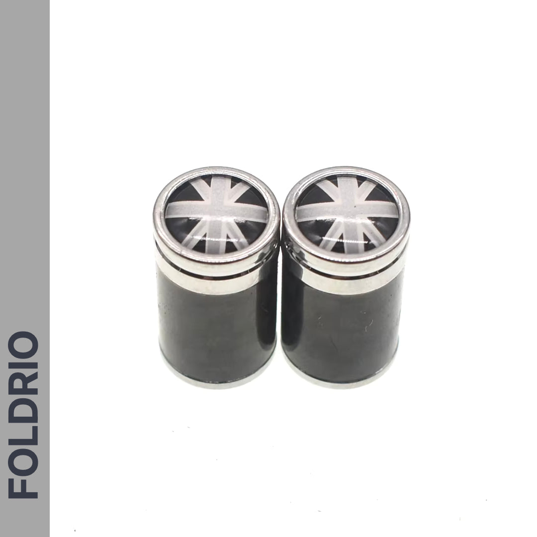 Two black FOLDRIO containers with metallic Union Jack lids sit side by side on a white background. Perfect for storing Brompton Union Jack Valve Caps – Schrader (A/C/G Line). "FOLDRIO" is printed vertically on the left container.