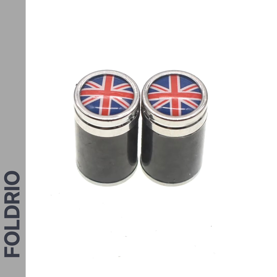 Two black cylindrical Brompton Union Jack Valve Cap containers (Schrader, A/C/G Line) by FOLDRIO feature silver tops and a Union Jack design, side by side on white, with FOLDRIO written vertically on the left.