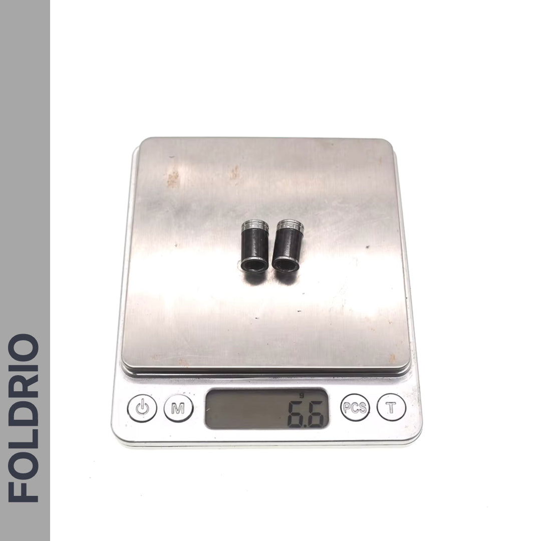 Two Brompton Union Jack Valve Caps – Schrader (A/C/G Line) by FOLDRIO are on a digital scale showing 6.6g. The word FOLDRIO appears vertically on the left side of the image.