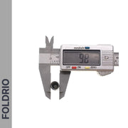 A digital caliper measures a Brompton Union Jack Valve Cap – Schrader (A/C/G Line), showing 9.8 mm on the screen. The left side has a vertical gray bar with "FOLDRIO" in bold capital letters.