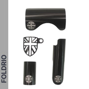 Four black metallic Brompton Frame Protector parts from FOLDRIO, each with a silver British flag design, are arranged on a white background. The brand name FOLDRIO appears vertically in bold along the left side.