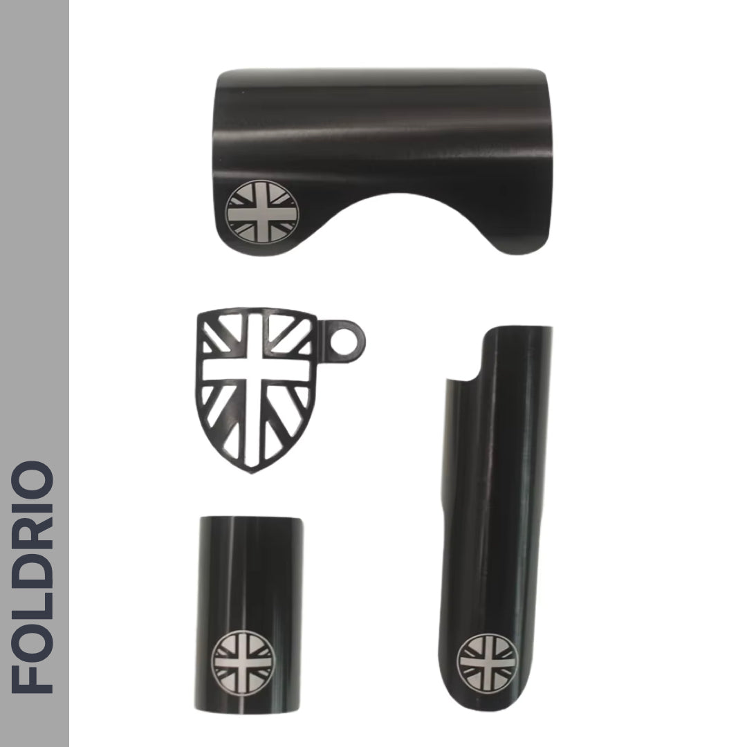 Four black metallic Brompton Frame Protector parts from FOLDRIO, each with a silver British flag design, are arranged on a white background. The brand name FOLDRIO appears vertically in bold along the left side.
