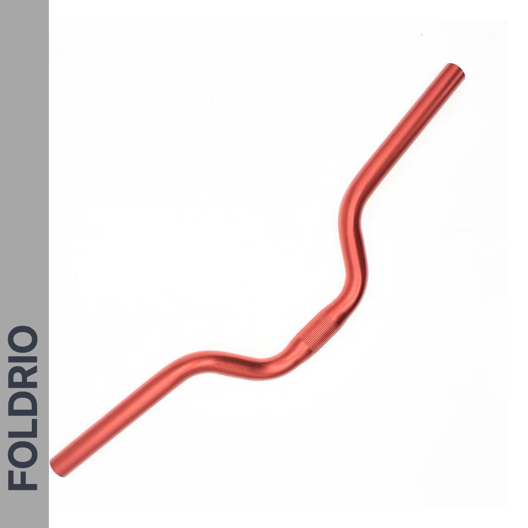 The Brompton M Handlebar – Anodised Aluminium, shown in red and curved for an upright ride, is displayed diagonally on white. A gray left strip features "FOLDRIO" in bold black, emphasizing style and fit for Brompton bikes. Available in 5 colours.