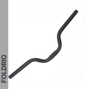 A Brompton M Handlebar in anodised aluminium, shown in black and designed for an upright riding position, is displayed on a white background. The word FOLDRIO appears vertically on a gray bar along the left edge.