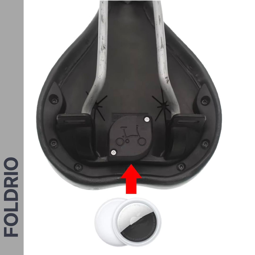 View of a Brompton AirTag Saddle Mount – Hidden Tracker Holder attached under a bicycle seat, indicated by a red arrow. FOLDRIO appears vertically on the left. A close-up of the anti-theft tracker is displayed at the bottom.
