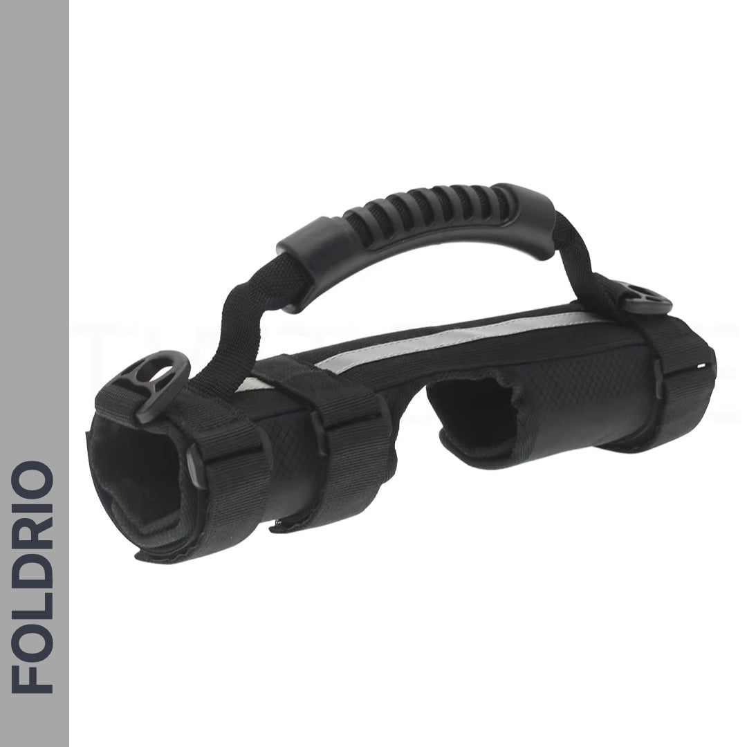 The Brompton Carry Handle & Shoulder Strap – Folded Bike Carrier, with a black soft-grip handle, adjustable straps, two circular openings, and sturdy build, is shown on a white background featuring the FOLDRIO logo for brand visibility.