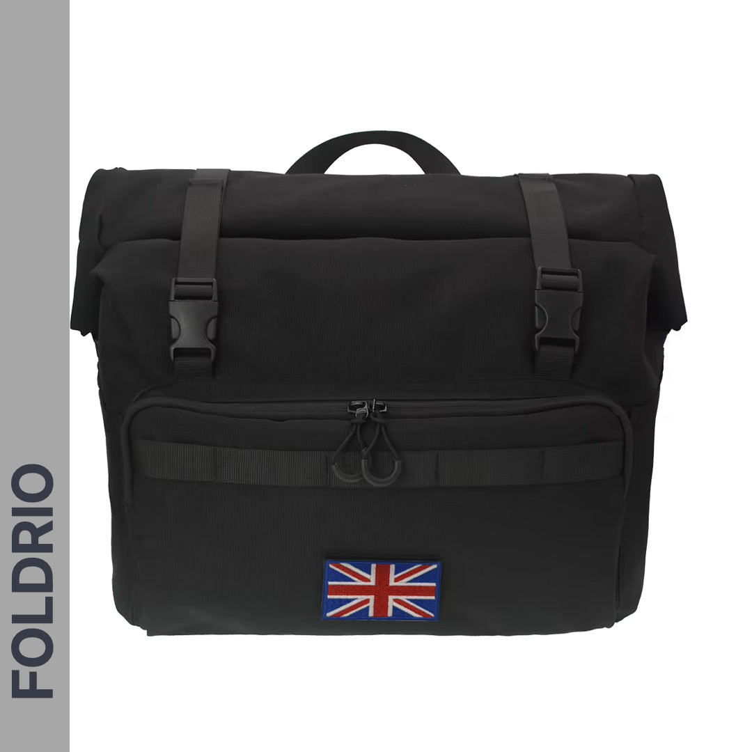 The FOLDRIO Brompton Roll-Top Front Bag (27.5L) is a black commuter and laptop bag, featuring a Union Jack front patch, dual top buckle closures, and “FOLDRIO” on a grey side strip. Compatible with the Brompton front carrier block.