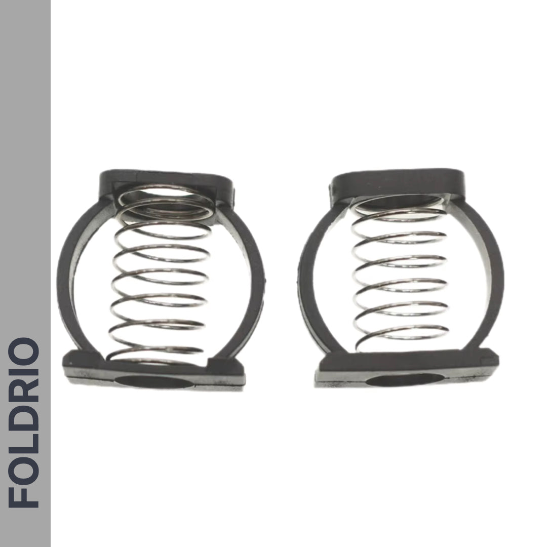 Two Brompton Stem Fixing Buckle Springs from FOLDRIO with black plastic frames are displayed side by side on a white background. "FOLDRIO" is printed vertically on a gray stripe along the left edge.