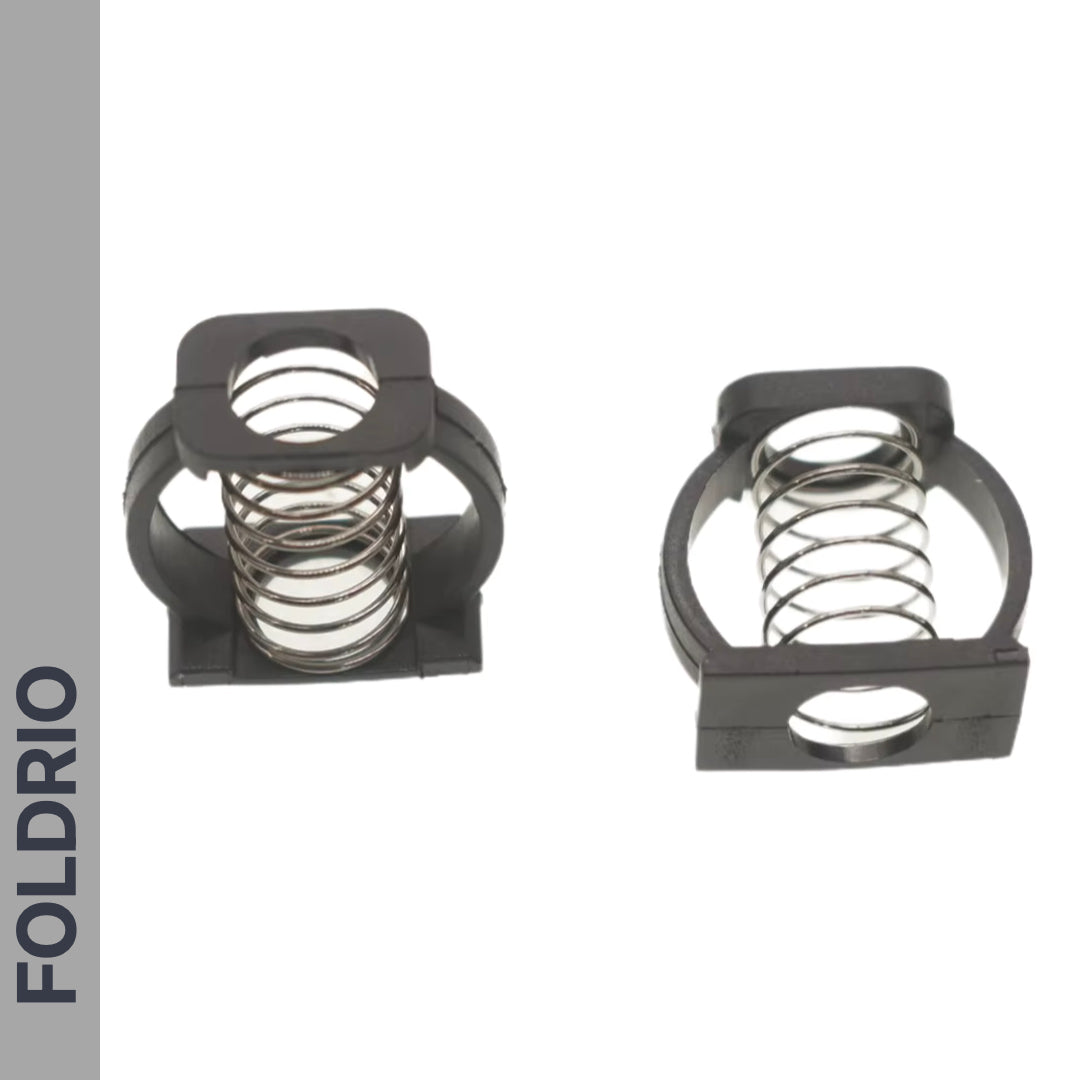 Two Brompton Stem Fixing Buckle Springs by FOLDRIO are shown encased in black rectangular plastic frames on a white background, with "FOLDRIO" written vertically on a gray sidebar to the left.