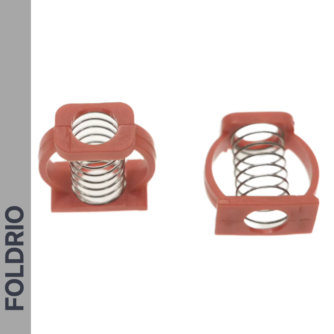 Two red Brompton Stem Fixing Buckle Springs from FOLDRIO—made of plastic and metal—are shown on a white background, one facing forward and one sideways. "FOLDRIO" appears vertically on a gray strip to the left.