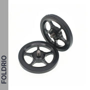 Two black, round Brompton Easy Wheels with five spokes and titanium bolts are shown on a white background. FOLDRIO branding appears vertically on a gray sidebar, highlighting these ultra-light bike accessories.
