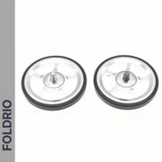 Two silver and black Brompton Easy Wheels with titanium bolts by FOLDRIO are placed side by side on a white background, with the FOLDRIO logo displayed vertically on a gray strip along the left edge.