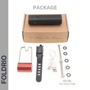 FOLDRIO Brompton Front Fork Light package includes a black 400-lumen USB-C rechargeable light, brown box, red bracket, black strap mount, white USB cable, and three silver M5/M6 bolts with nuts.