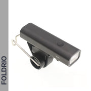 The FOLDRIO Brompton Front Fork Light is a sleek, black, rectangular bike light with 400 lumens brightness, a top power button, and an underside mounting bracket. "FOLDRIO" appears vertically on a gray left sidebar. USB-C rechargeable.