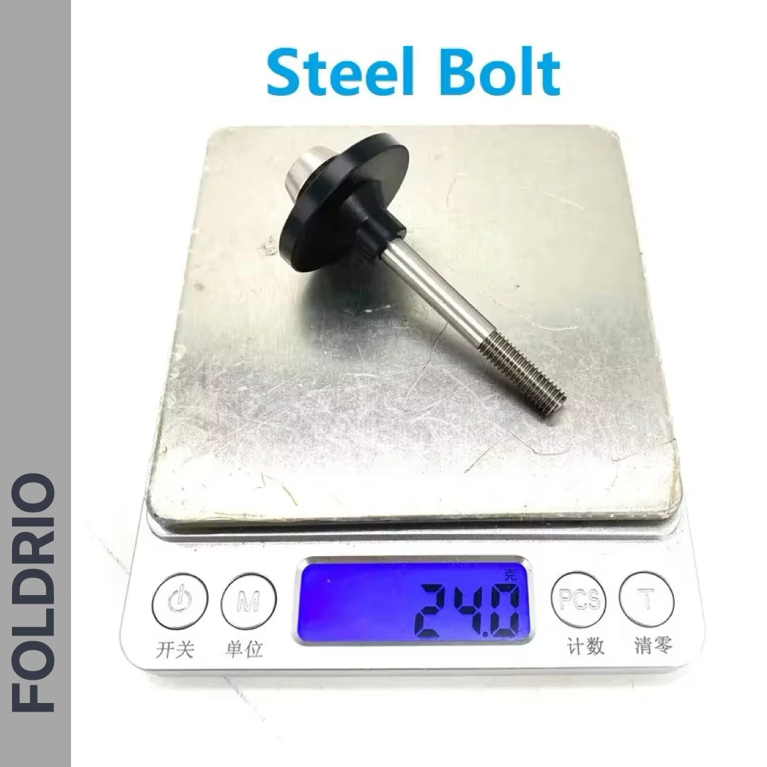 A FOLDRIO Brompton Rear Shock Absorber rests on a digital scale, displaying 24.0 grams. The black-flanged steel part is labeled above the scale, indicating its use as suspension material for Brompton folding bikes.