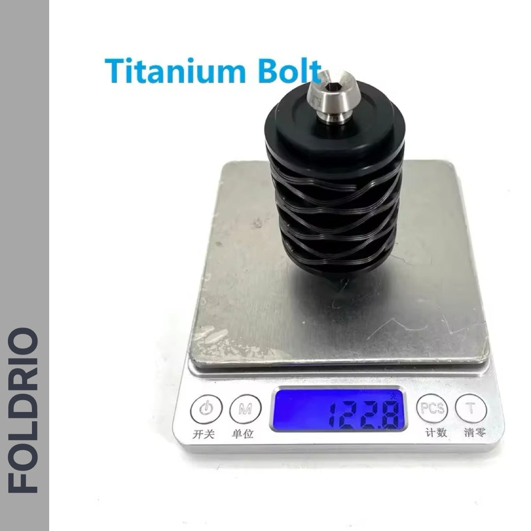 A FOLDRIO Brompton Rear Shock Absorber with a titanium bolt is placed on a digital scale reading 123.8g. "Titanium Bolt" is noted above, and FOLDRIO appears vertically on the side.