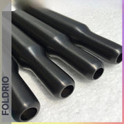 Four multicolour titanium cylindrical seatposts with rounded ends, branded FOLDRIO, are arranged parallel on a textured white surface. "FOLDRIO" is displayed vertically along the left side of the image.