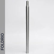 A straight, metallic Brompton Titanium Seatpost – Multicolour Edition stands upright on a plain white background. The word FOLDRIO is printed vertically along a gray bar on the left side.