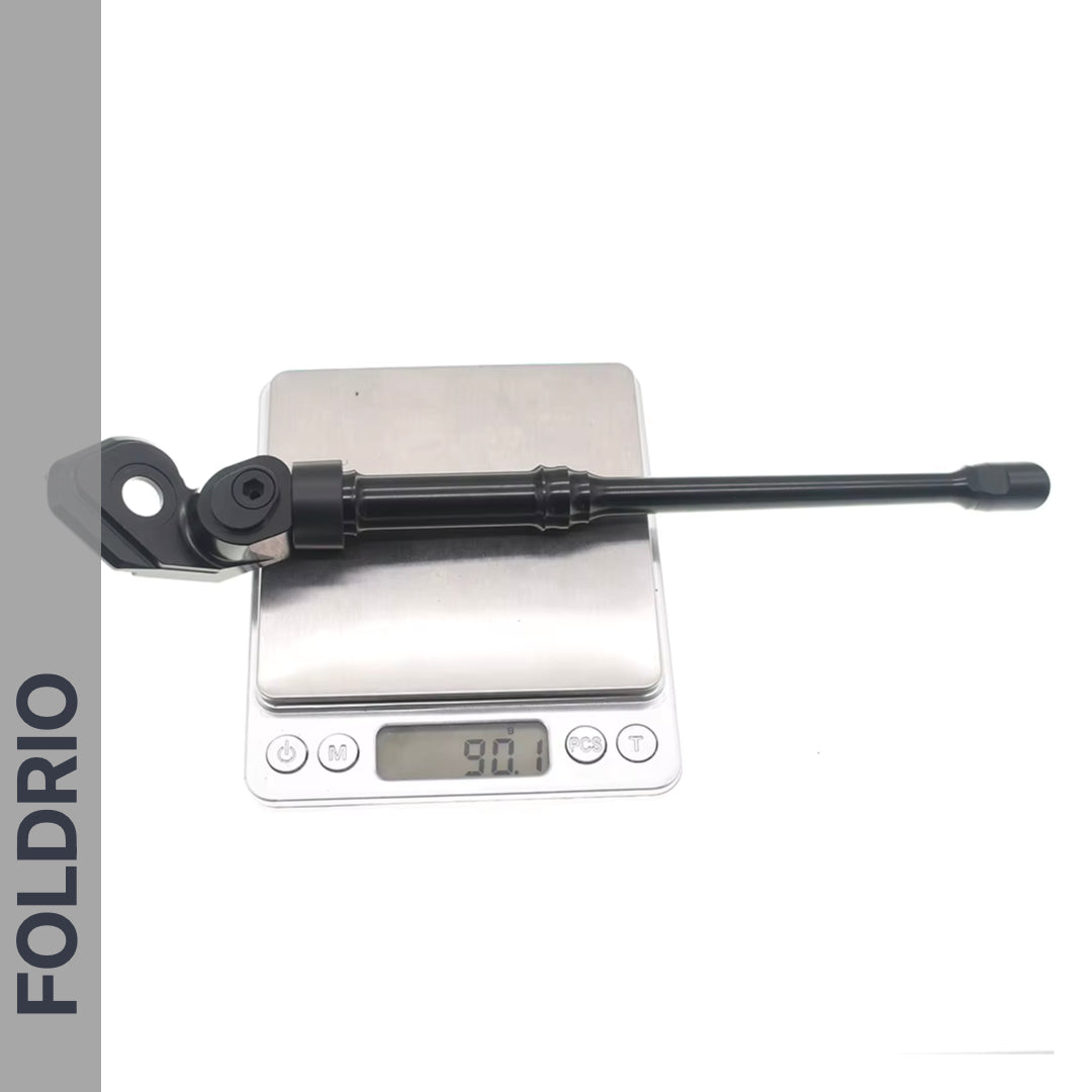 A FOLDRIO Brompton Kickstand – Adjustable Aluminium for A and C Line bikes rests on a digital scale reading 90.1g. The background is white, with "FOLDRIO" vertically on the left.