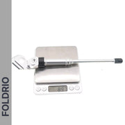 A Brompton Kickstand – Adjustable Aluminium (A and C Line) by FOLDRIO is shown on a digital scale reading 89.7 grams, with the word FOLDRIO displayed vertically on the left side.