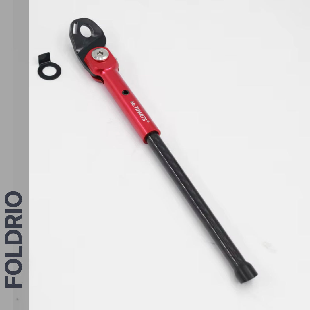 A Brompton Kickstand – Carbon Fibre, P and T Line by FOLDRIO, shown in red and black with a mounting bracket on a white background. "FOLDRIO" is printed vertically on a gray bar to the left.