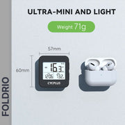 ULTRA-MINI AND LIGHT: The FOLDRIO Brompton GPS Bike Computer – Wireless, IPX6, 9 Data Fields (57mm x 60mm, 71g), with digital display, sits next to wireless earbuds in a case.