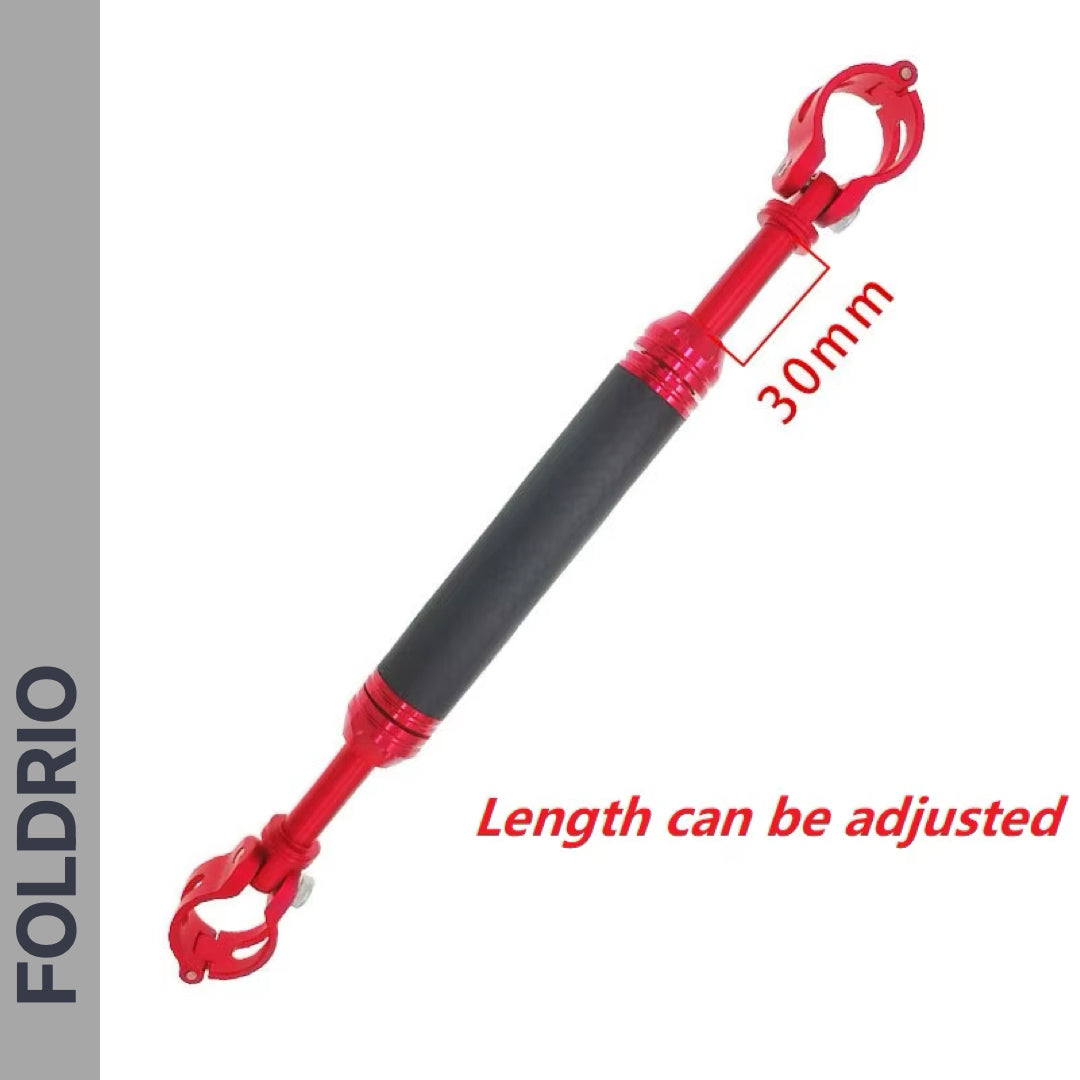 A FOLDRIO Brompton M Handlebar Cross Brace—Adjustable, carbon fibre look, with black grips and clamping ends. Available in 6 colours; length adjustable. “FOLDRIO” marked vertically on the left; “30mm” in red text.