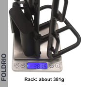 A FOLDRIO Brompton Front Bag Rack Holder with Elastic Straps is shown on a digital scale reading 381.5g, with "FOLDRIO" printed vertically and "Rack: about 381g" below—an ideal accessory for your Brompton.
