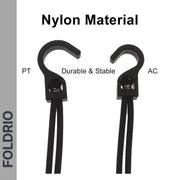 Two black nylon hooks labeled PT and AC are displayed with cords attached. Ideal as Brompton Rear Rack Elastic Straps for AC Line (old) & PT Line (new). "Nylon Material" appears above, "Durable & Stable" below, with a vertical FOLDRIO label on the left.