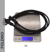 A coiled Brompton Rear Rack Elastic Strap by FOLDRIO, for AC Line (old) & PT Line (new), sits on a digital scale reading 39.0 grams. "FOLDRIO" is shown vertically at left; "AC" is labeled beneath the scale.