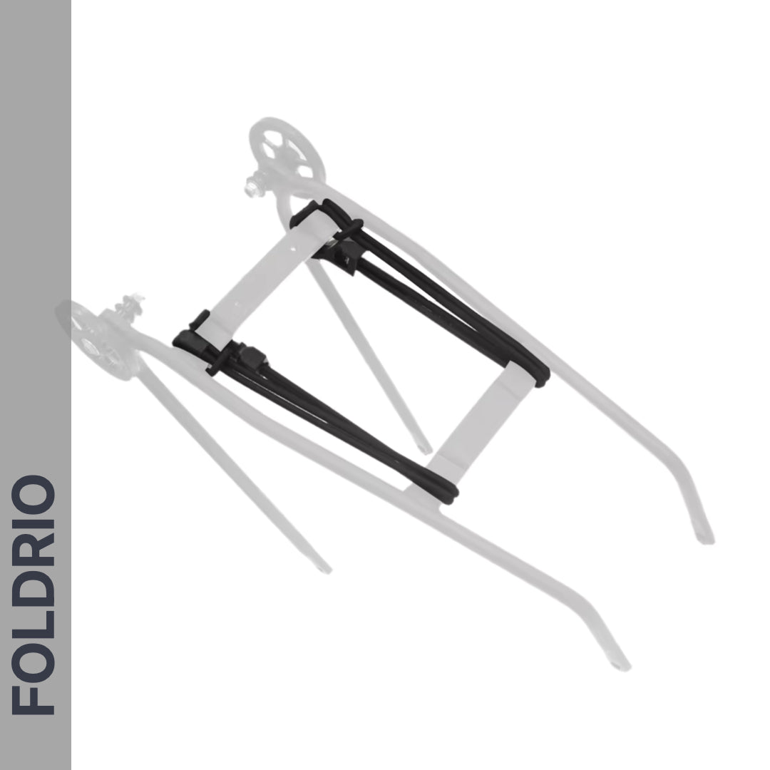 A FOLDRIO Brompton Rear Rack Elastic Strap secures a foldable metal stand with black hinges and wheels, shown with a transparent overlay to illustrate folding. The word FOLDRIO appears vertically on the left side. Fits AC Line (old) & PT Line (new).