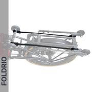 A grayscale close-up of a folded bicycle with a rear rack and FOLDRIO Brompton Rear Rack Elastic Straps – fits AC Line (old) & PT Line (new). "FOLDRIO" appears vertically on the left side against a gray background.