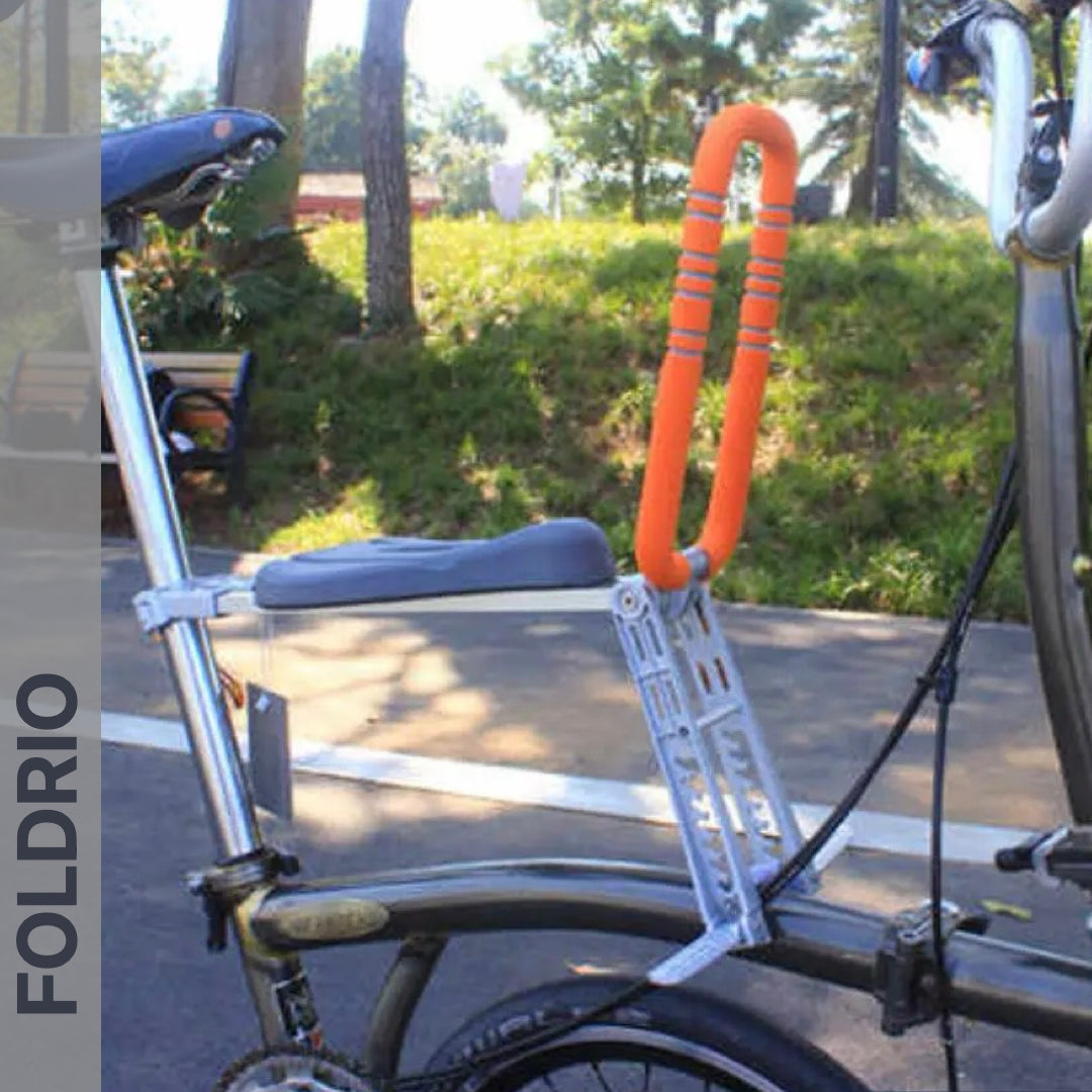 Brompton Brompton with gray frame and orange seat post lock, shown outdoors with Foldrio front child seat and safety bar | Foldrio. Foldrio
