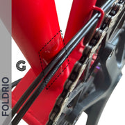 Brompton Brompton red frame rear triangle with black cables, chain, and dashed box highlighting FOLDRIO protection area | Foldrio. Foldrio