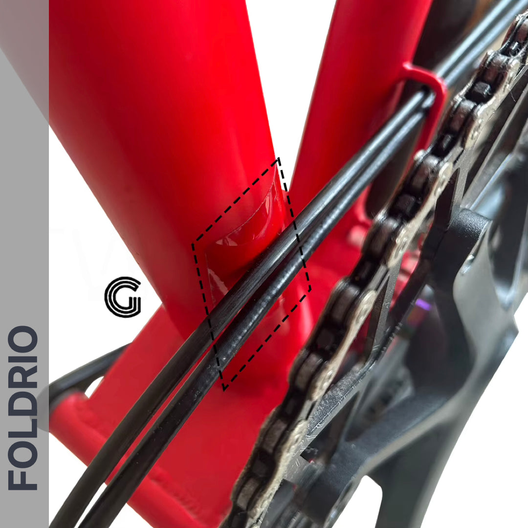Brompton Brompton red frame close-up showing chain-area scratches and black cables; grey FOLDRIO band left; dashed lines highlight damage | Foldrio. Foldrio